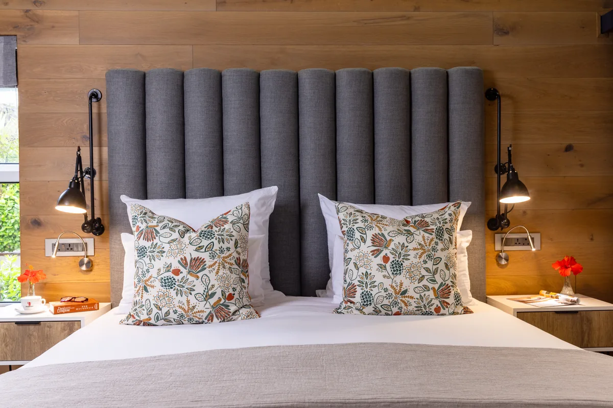 Deluxe Room bed with upholstered headboard at Majeka House Boutique Hotel