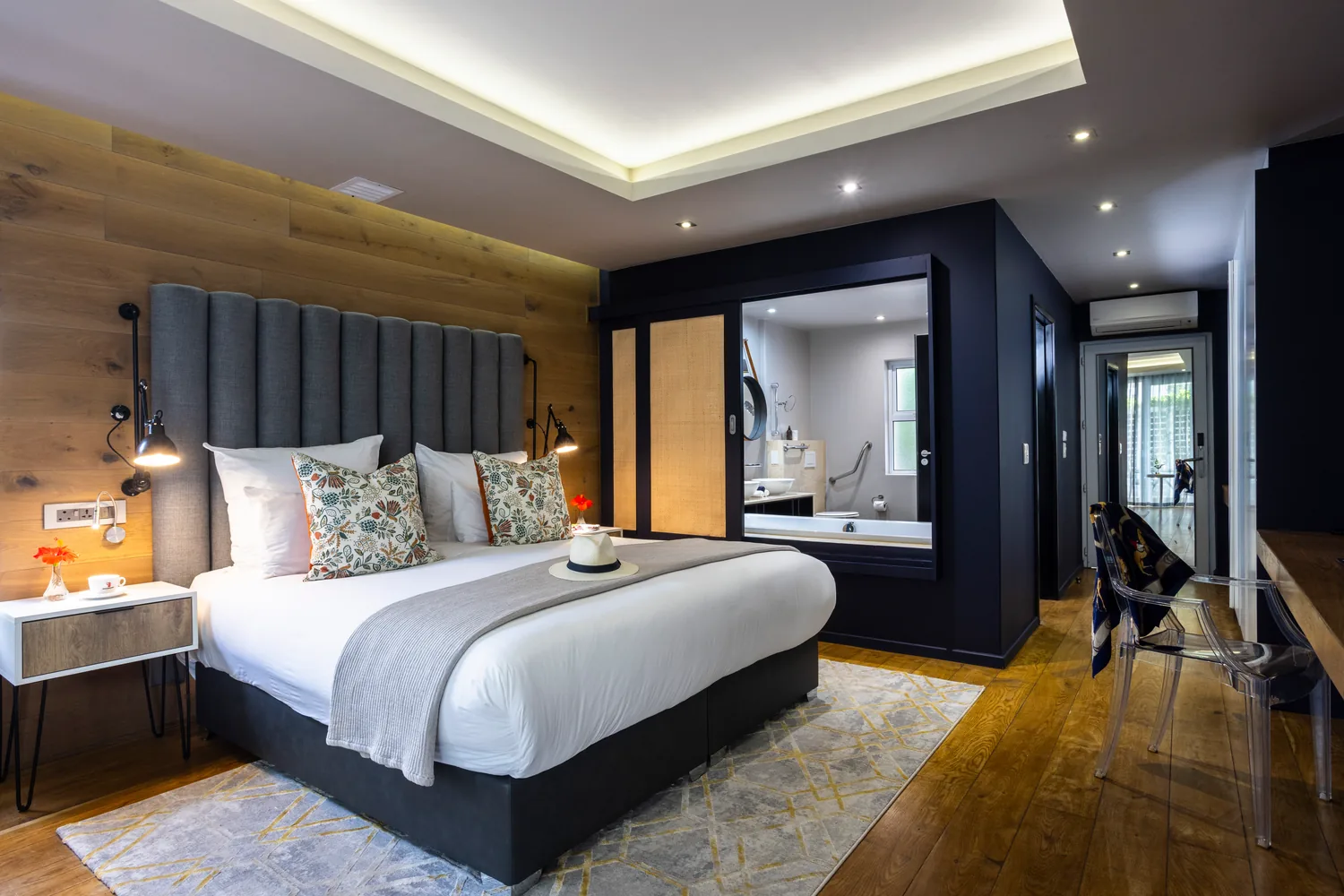 Deluxe Room with upholstered headboard and open bathroom at Majeka House Boutique Hotel