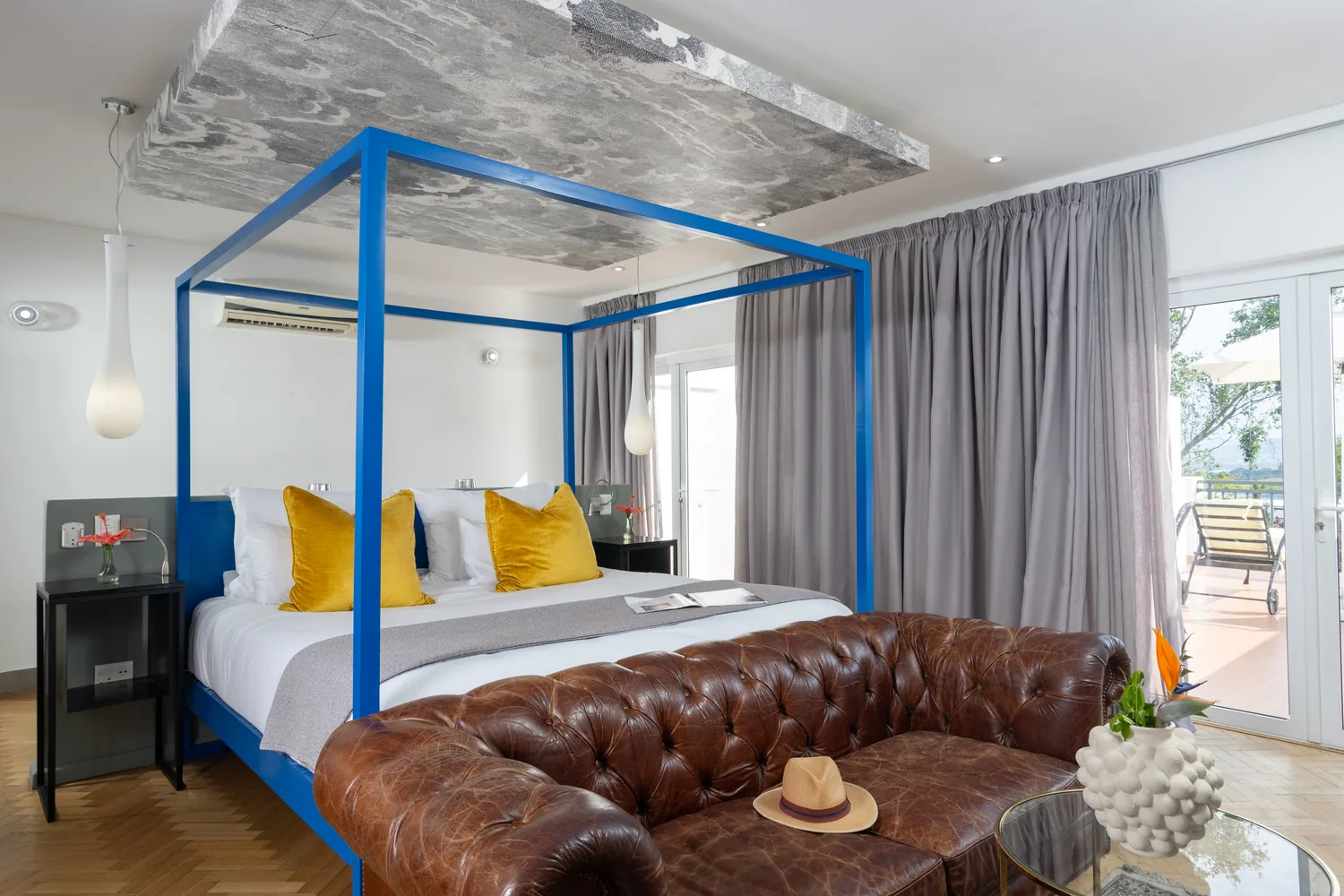 Mountain View Room with blue four-poster bed and leather sofa at Majeka House Boutique Hotel