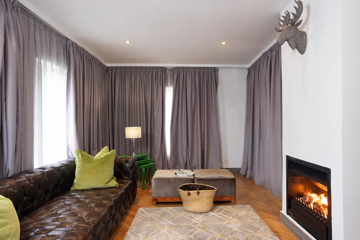 Mountain View Suite lounge with fireplace and leather sofa at Majeka House Boutique Hotel