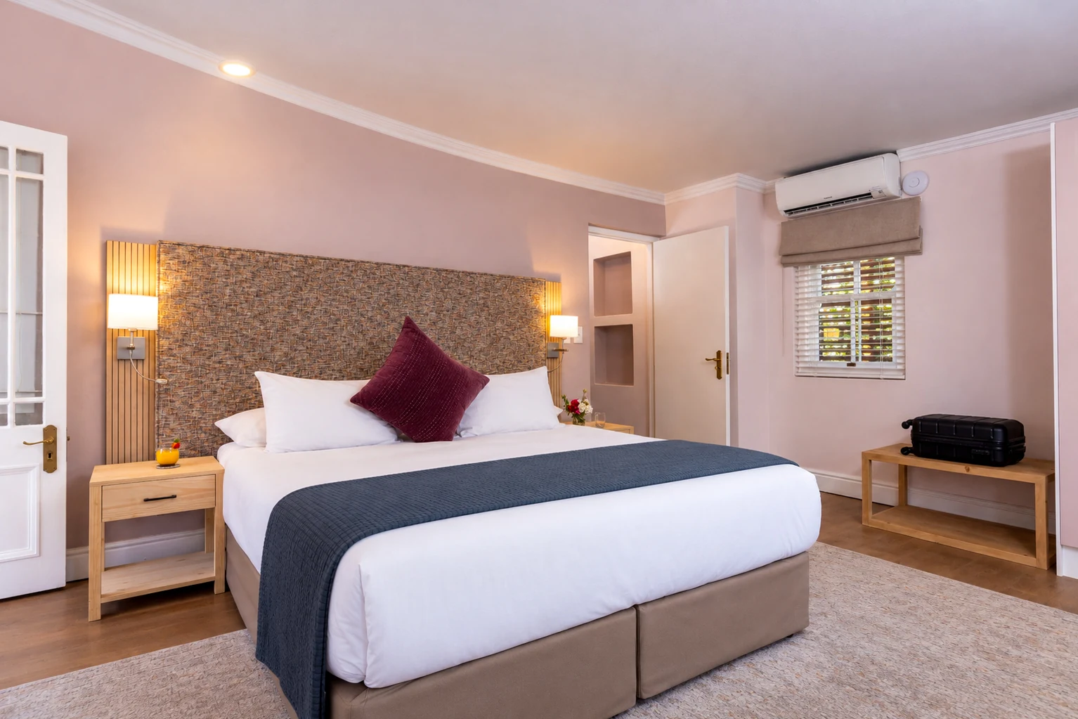Classic Room with a king bed, woven headboard and reading lamps at Plumwood Boutique Hotel